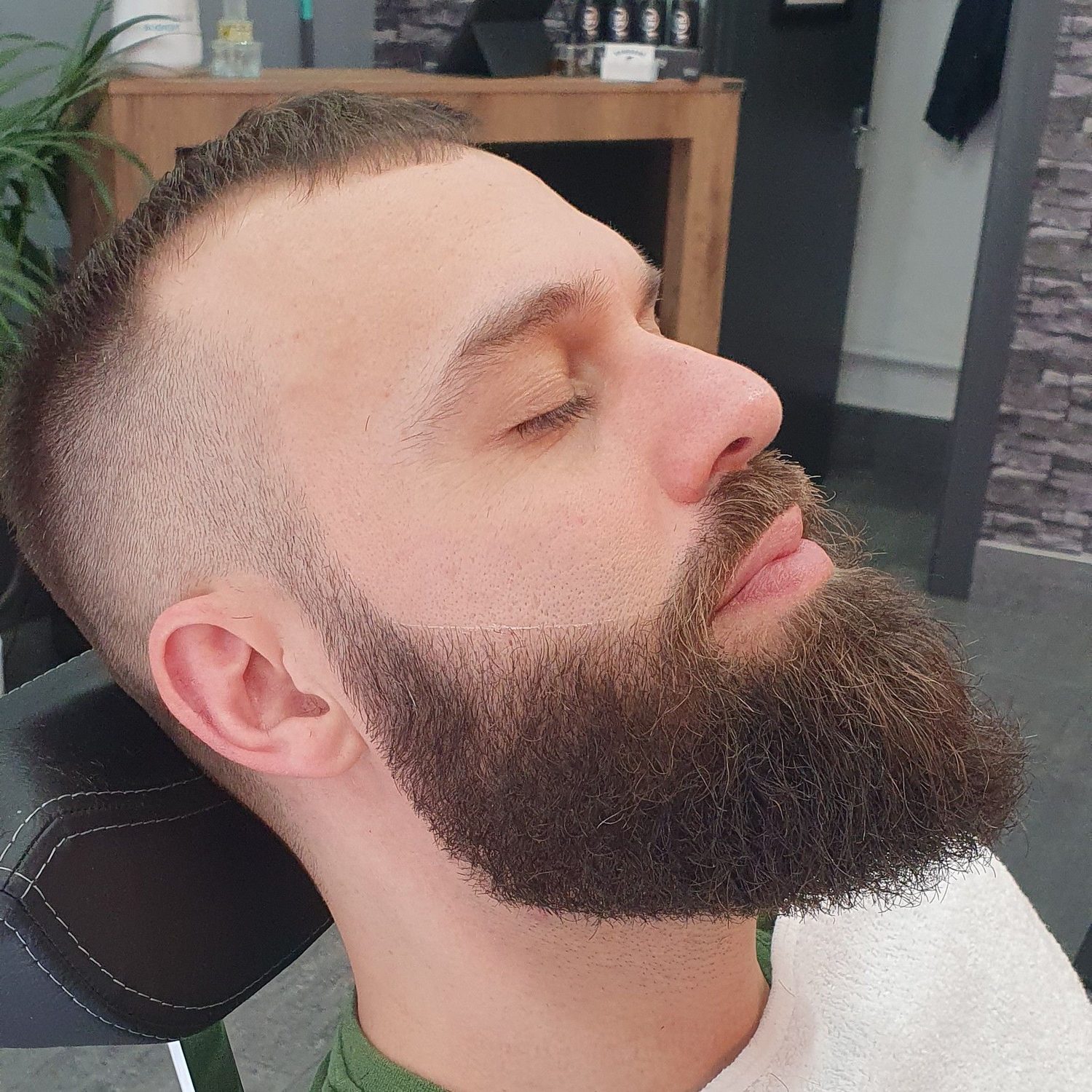 A skin fade with a full, sharply shaped beard