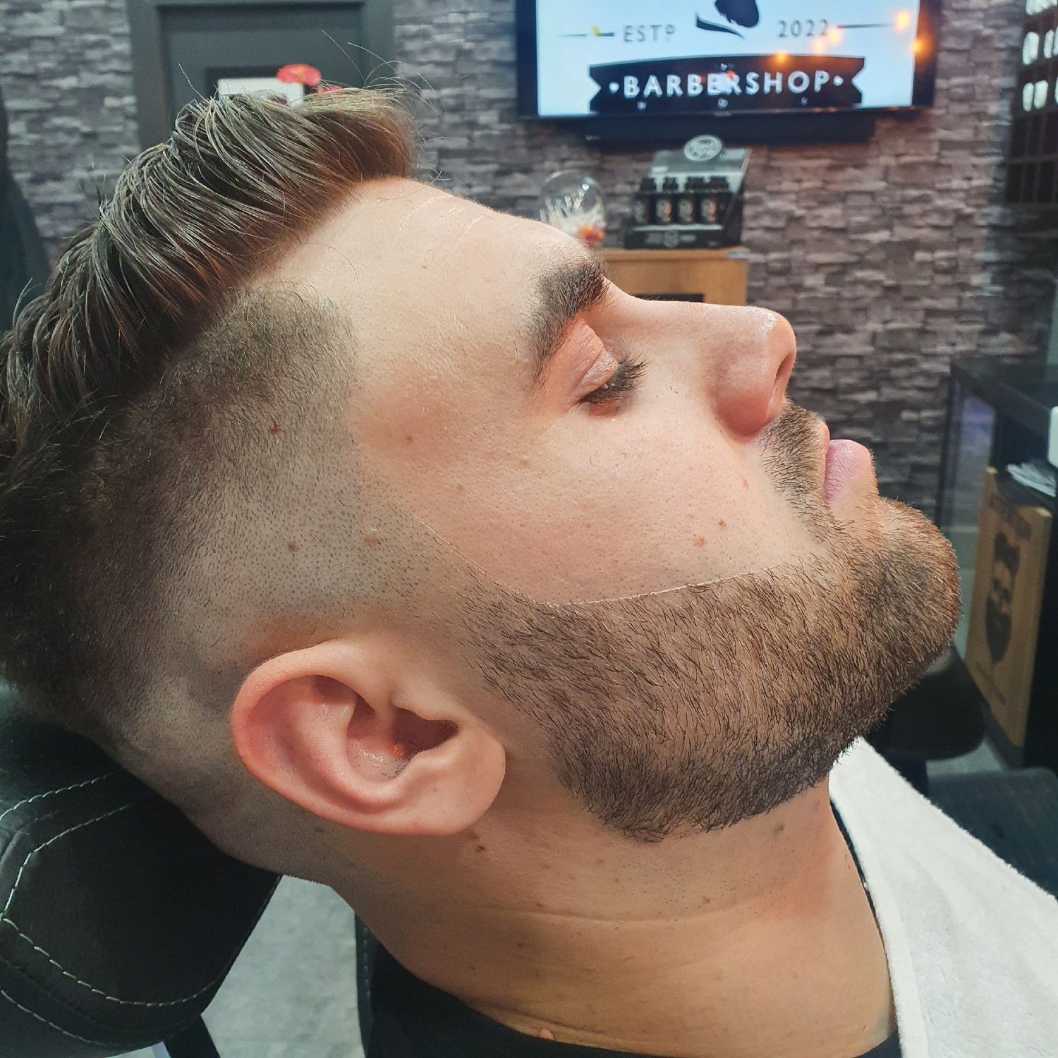 A quiff with a faded side and a lined beard
