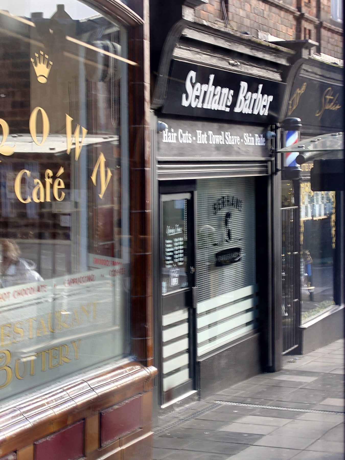 The shopfront on Crown Street: Serhans Barber in white lettering, a barber’s pole by the door